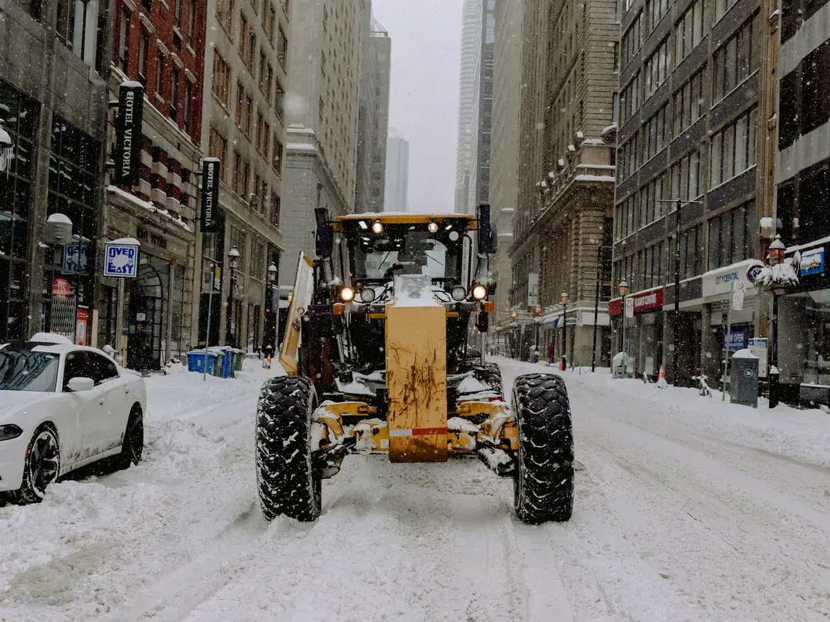 A wheel loader clearing a snow-covered downtown street