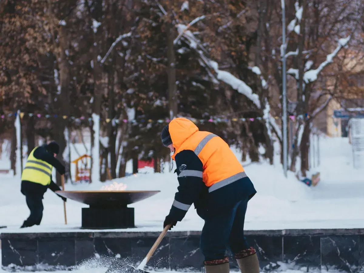 A crew in high-visibility vests clearing snow