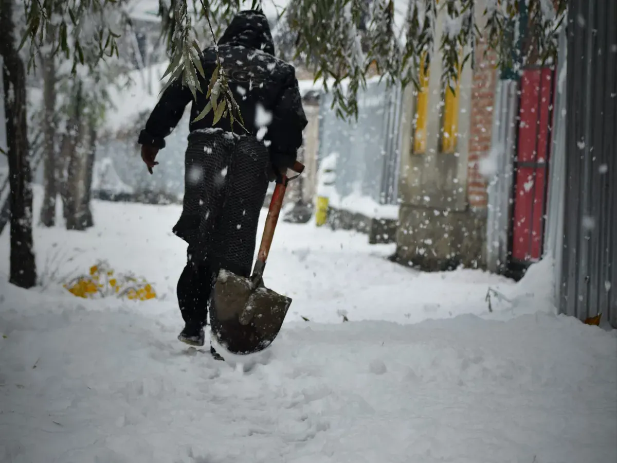 Person shovelling a snowy residential sidewalk
